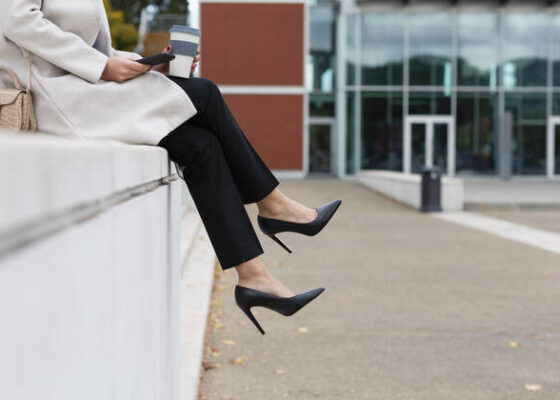 Businesswoman with smart phone sitting on wall model released, EIF03257